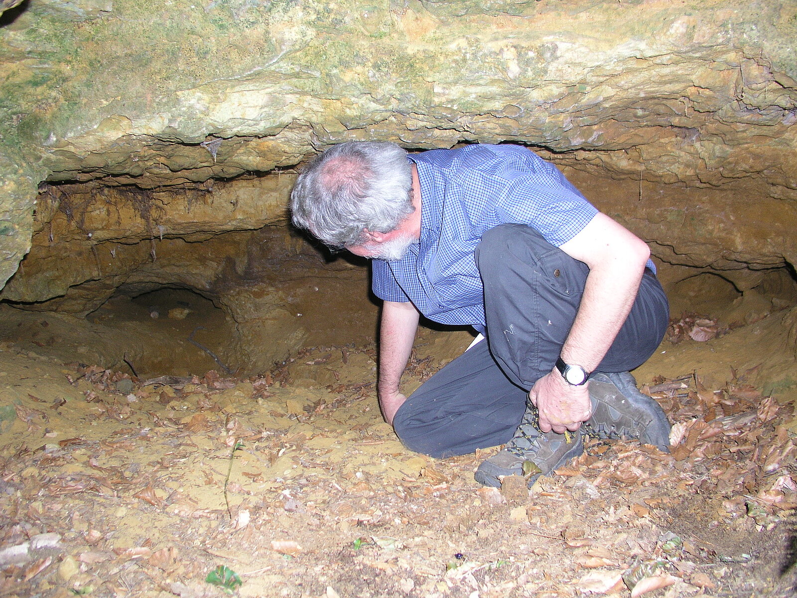 Mann sitzt gebückt in etwa 50 cm hoher Höhle