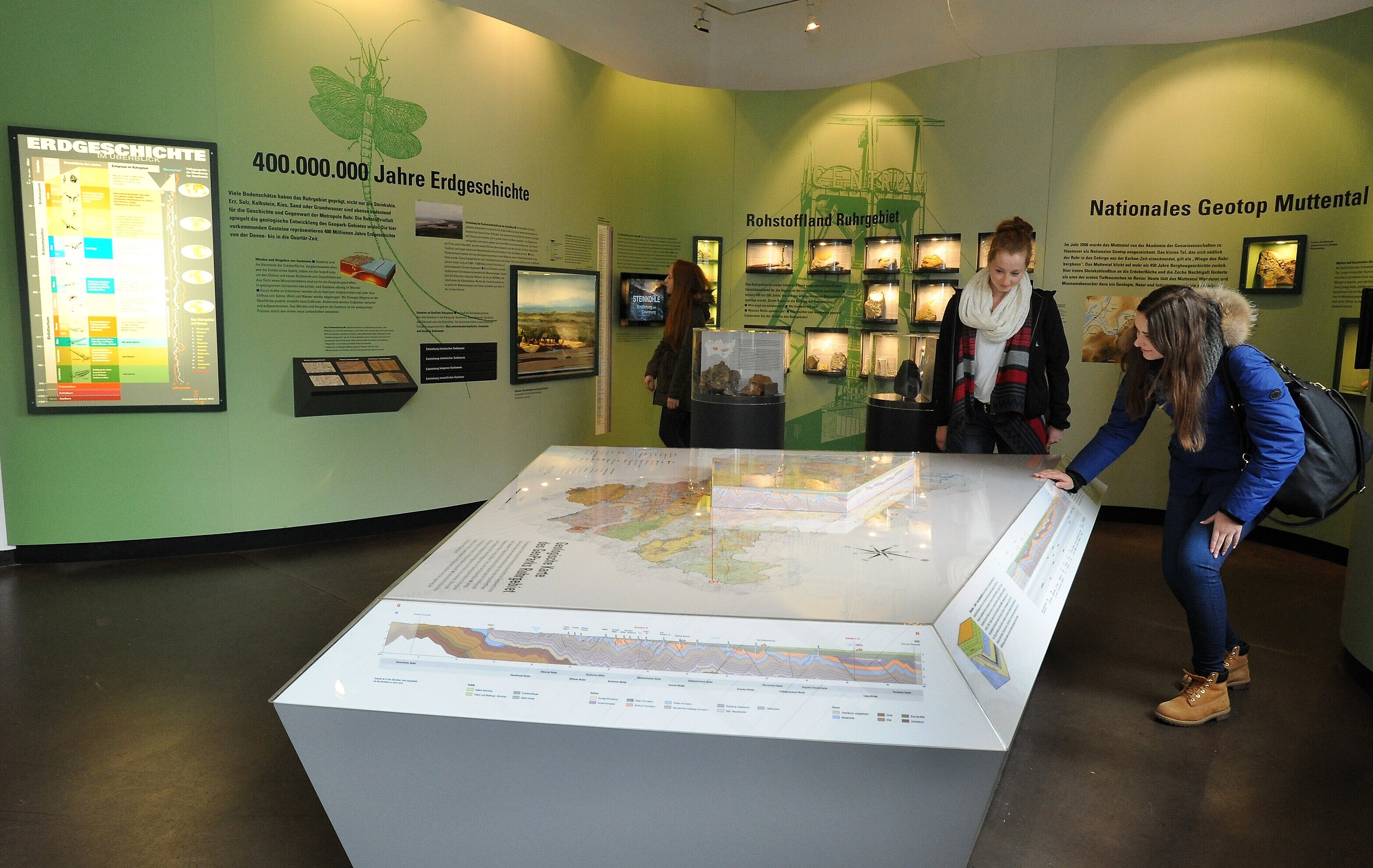 Besucher an Tisch mit geologischer Karte