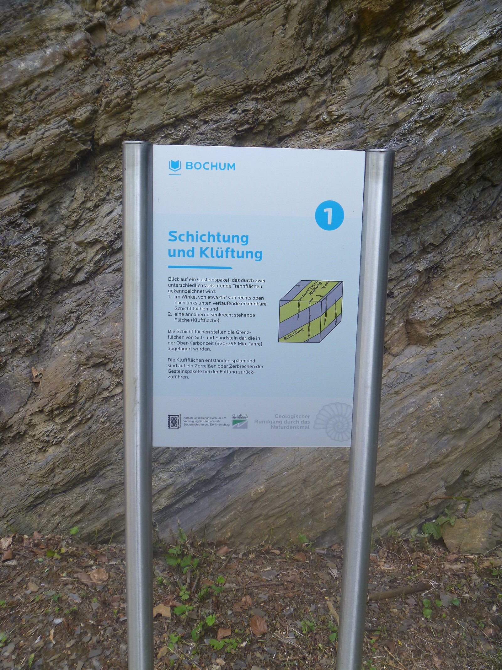 Infotafel vor Felswand.