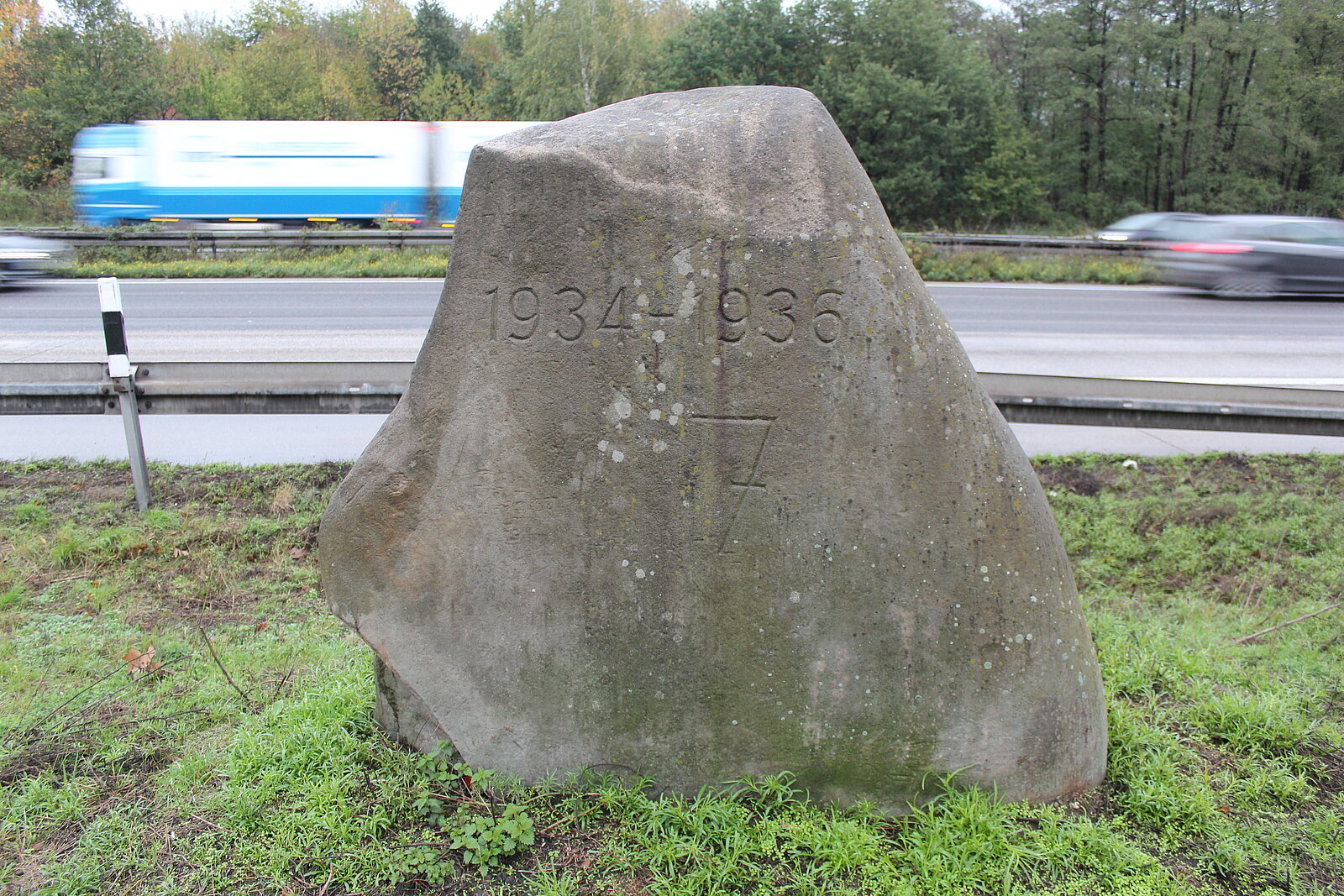 Gesteinsblock mit Inschrift "1934-1936 7." vor Autobahn.
