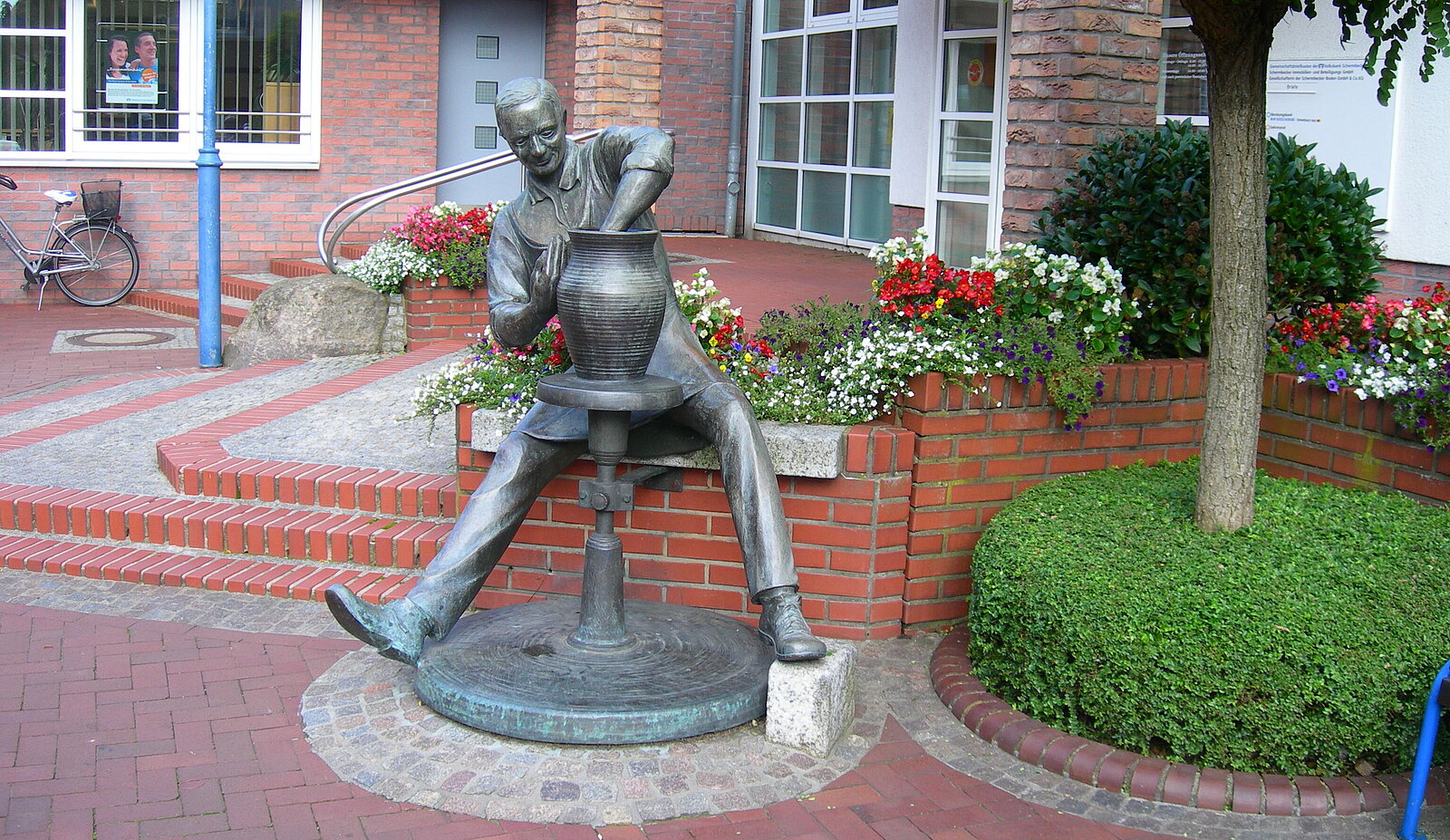 Mann sitzt an Töpferscheibe und stellt Vase her