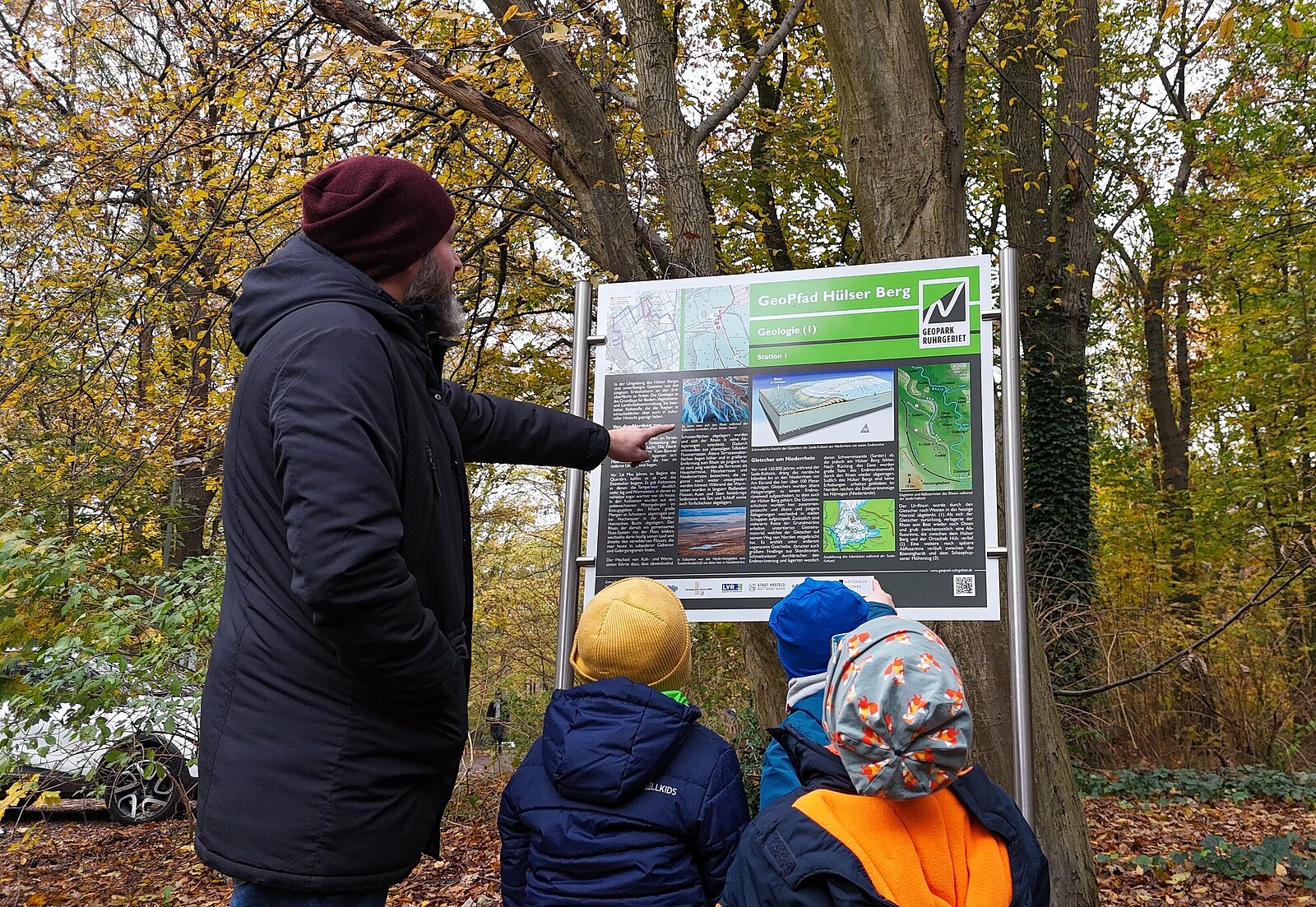Mann mit Kindern an Infotafel