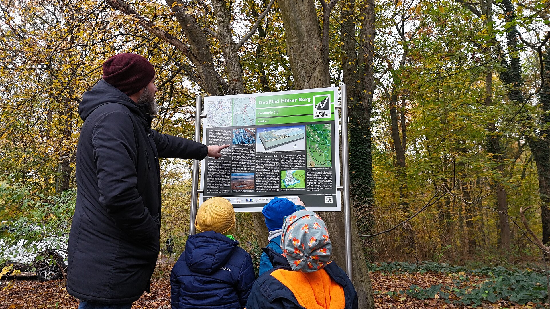 Mann mit Kindern an Infotafel