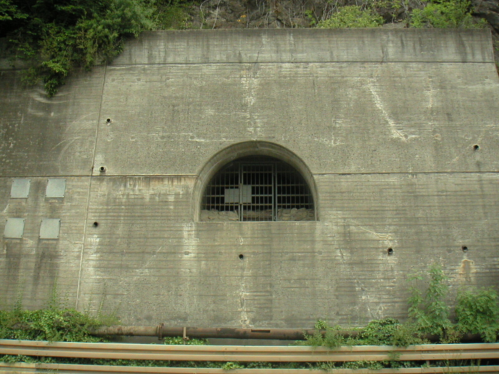 Vergitterter Eingang in Betonmauer