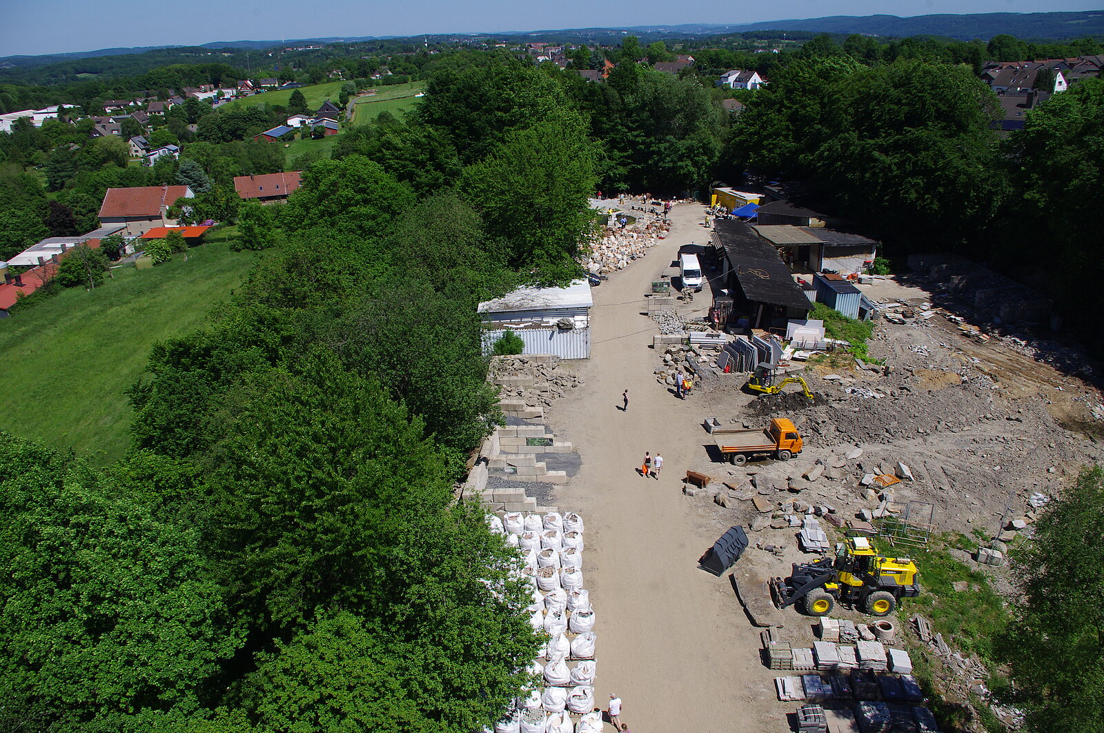 Luftbild mit Blick auf Nutzfahrzeuge und Steinbruchprodukte