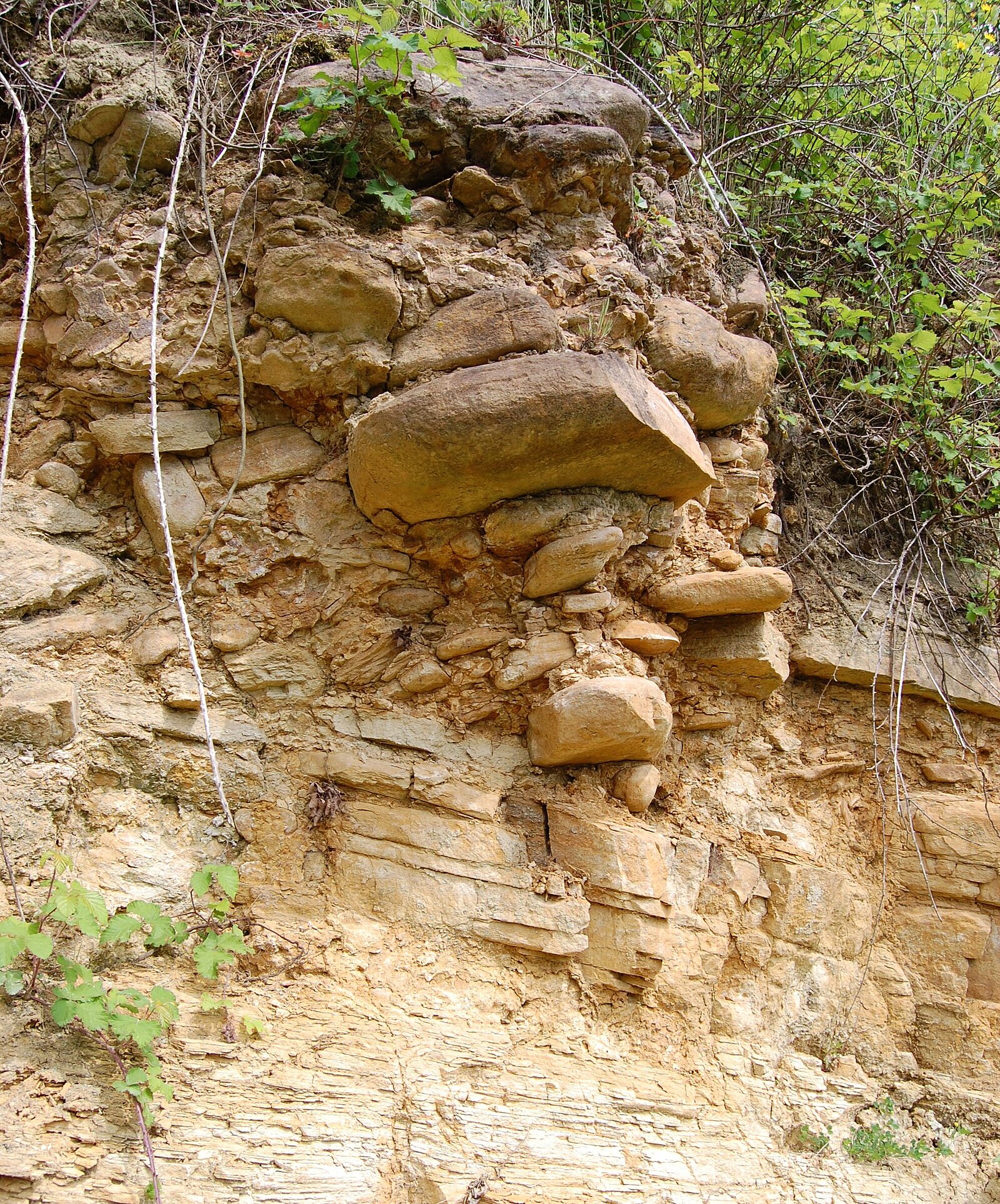 Rundliche Gesteinsblöcke im oberen Teil einer Felswand