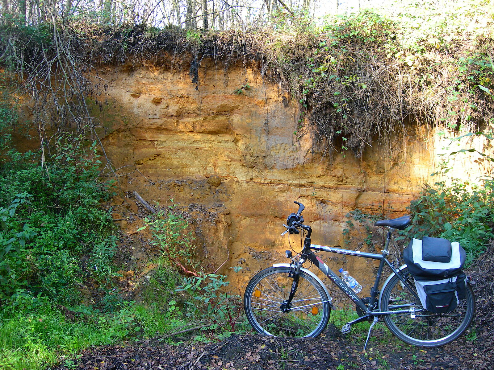 Wand mit rot-gelben Sanden und Fahrrad im Vordergrund