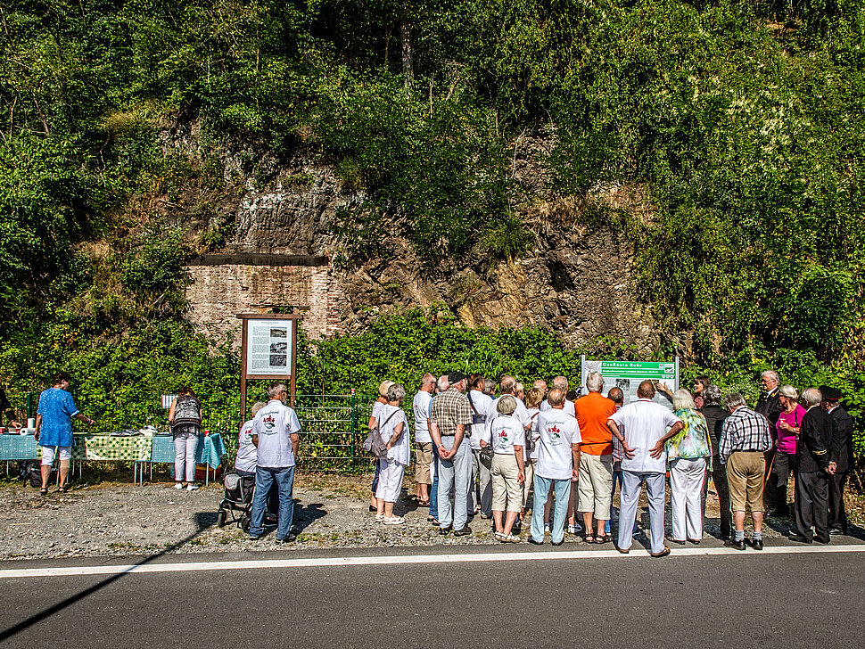 Aufschluss mit Infotafeln und Gruppe von Menschen