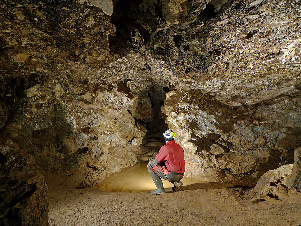 Mann im roten Höhlenanzug in Höhle