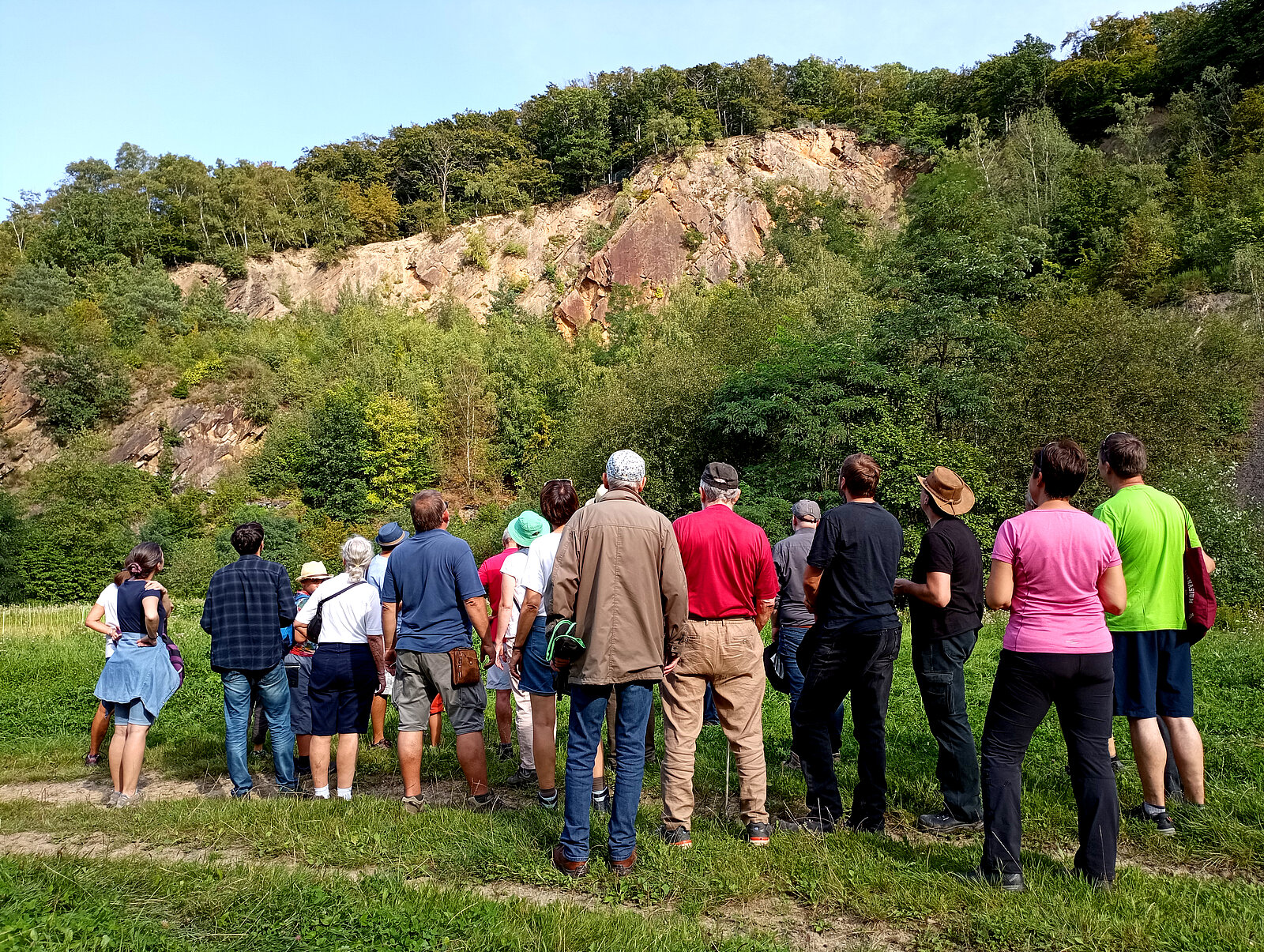 Besuchergruppe vor Felswand