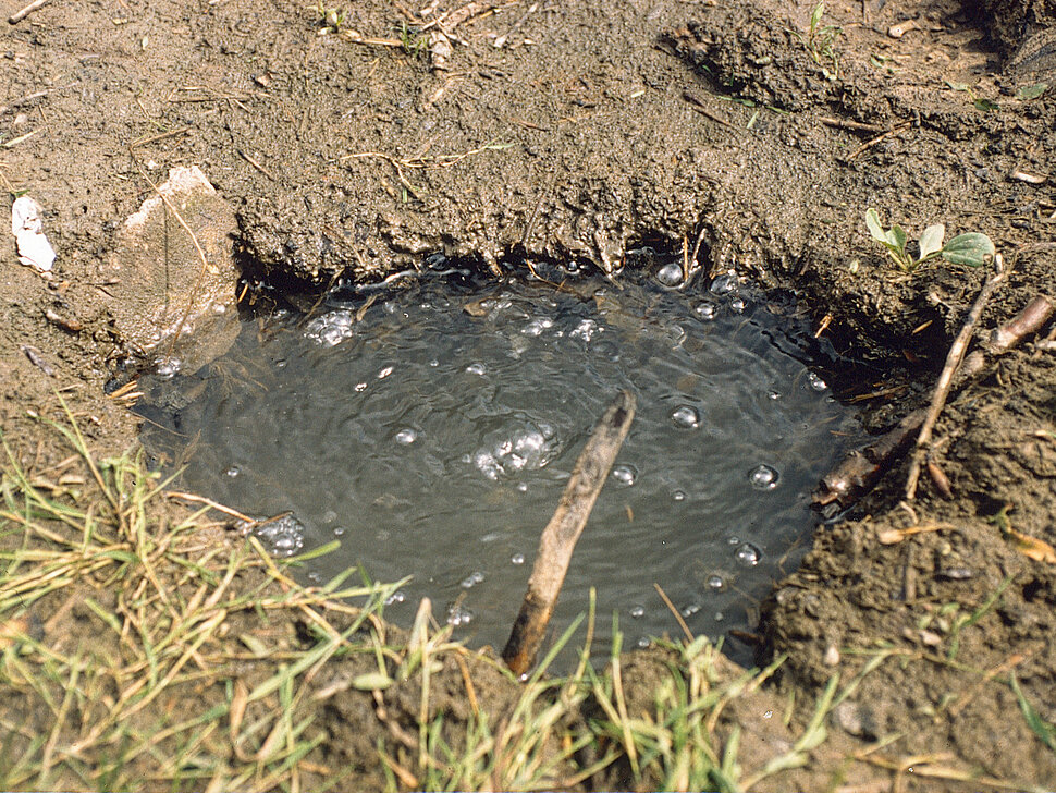 Wassergefülltes Loch mit Gasblasen