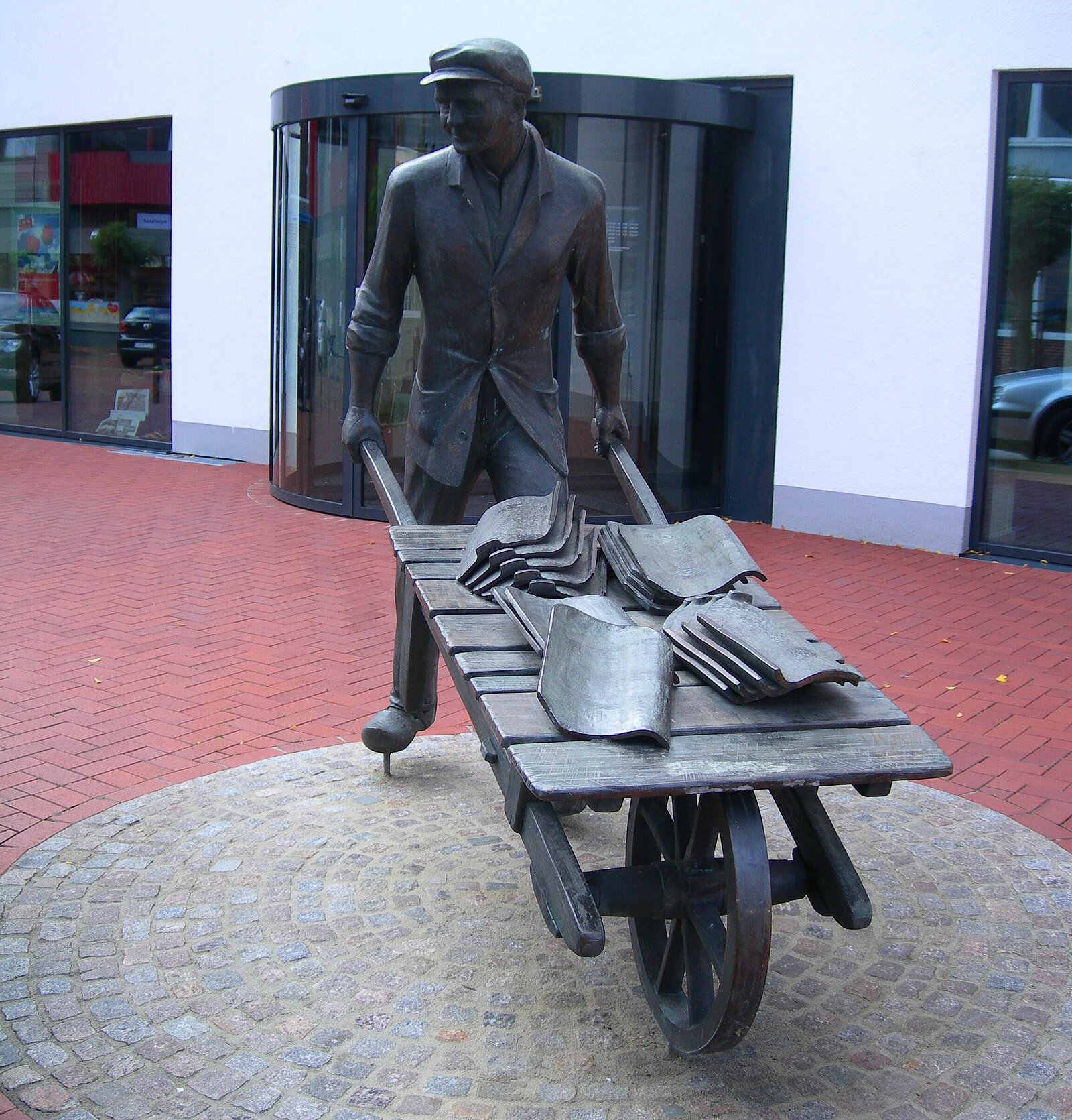 Mann mit Schubkarre und Ziegeln