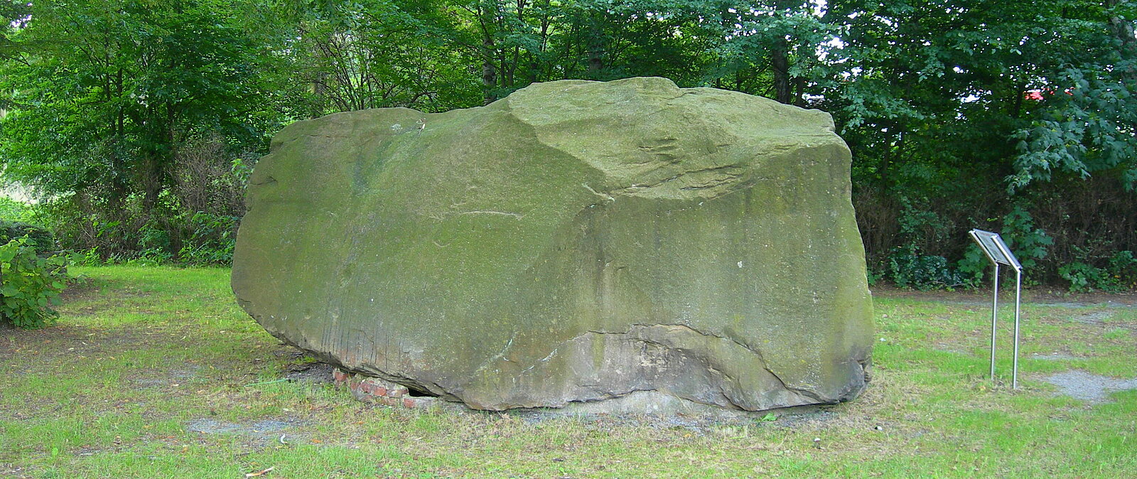 Mehr als mannshoher Felsbrocken mit Infotafel