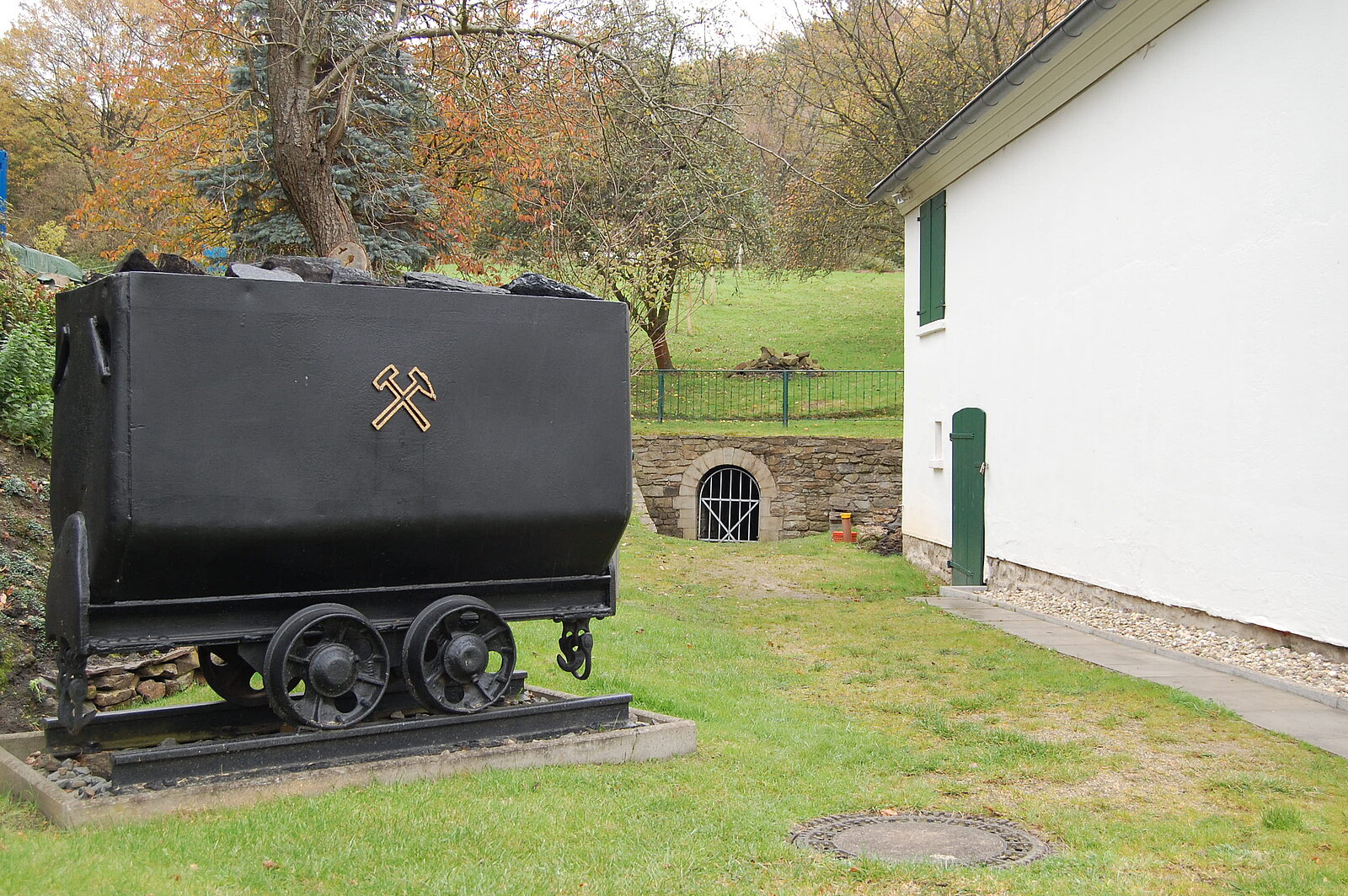 Grubenwagen mit Stolleneingang im Hintergrund