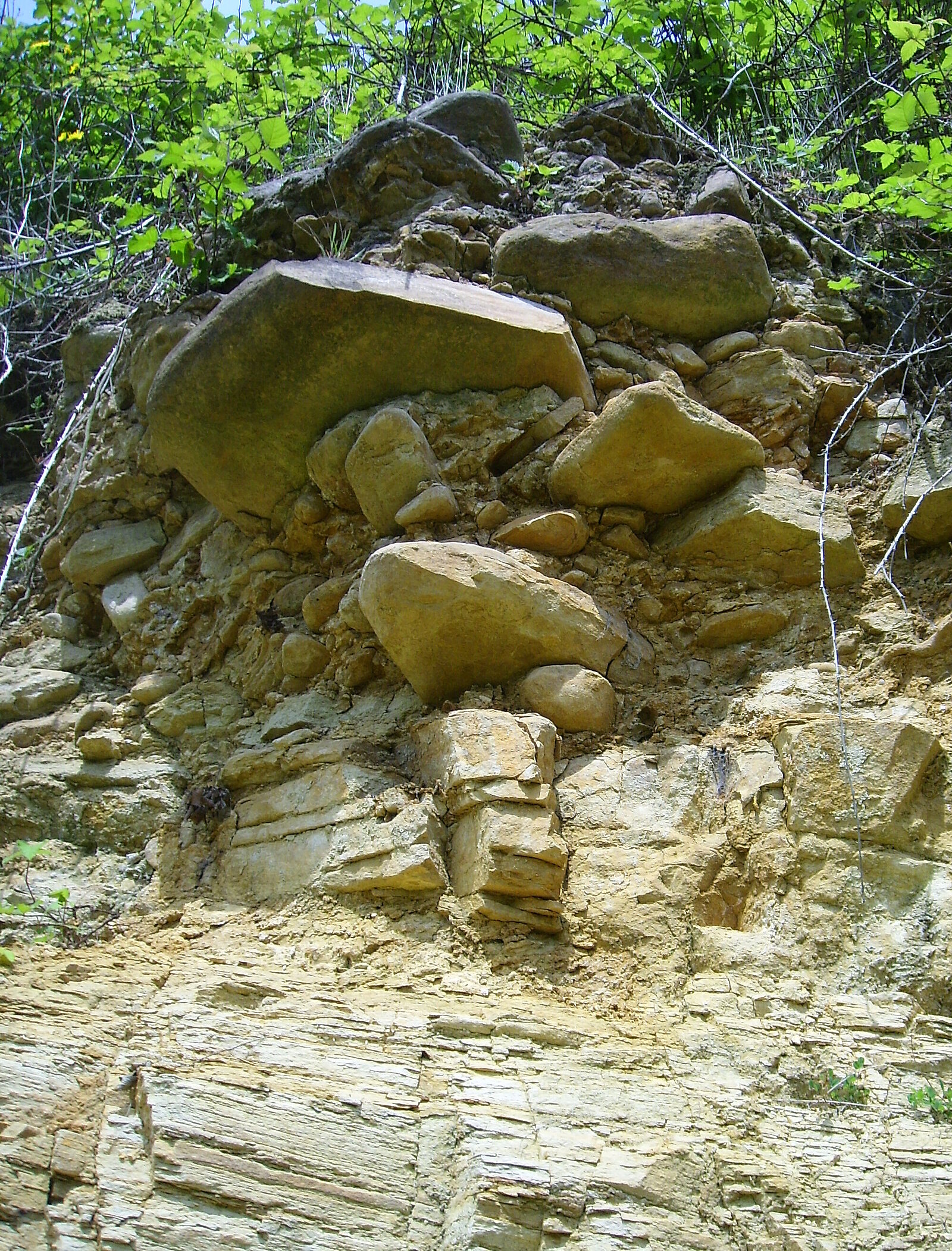 Rundliche Gesteinsblöcke im oberen Teil einer Felswand