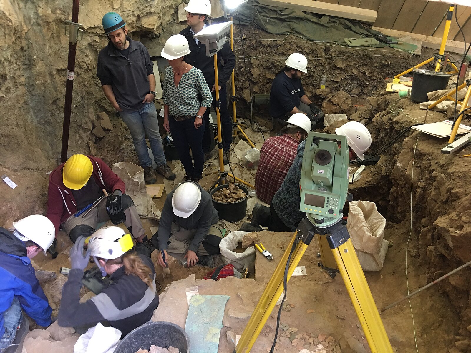 Leute mit Helmen in der Höhle bei der Arbeit.