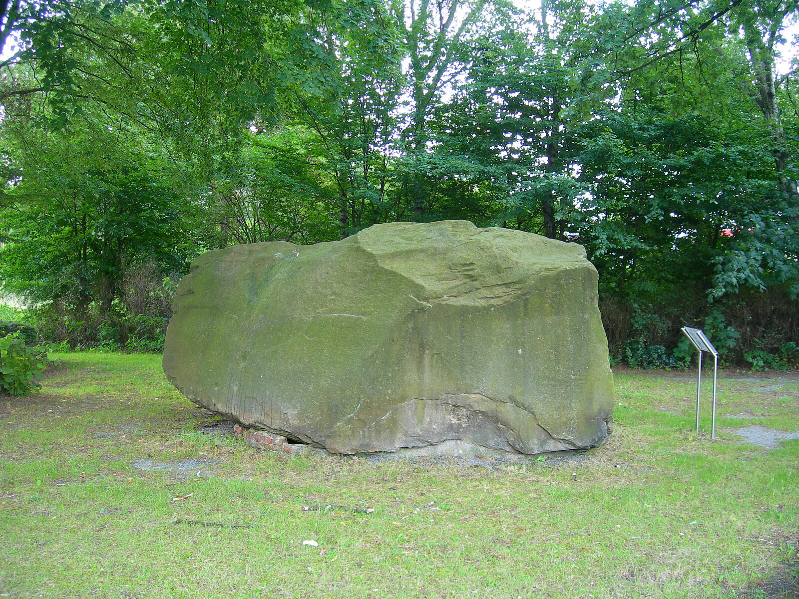 Mehr als mannshoher Felsbrocken mit Infotafel