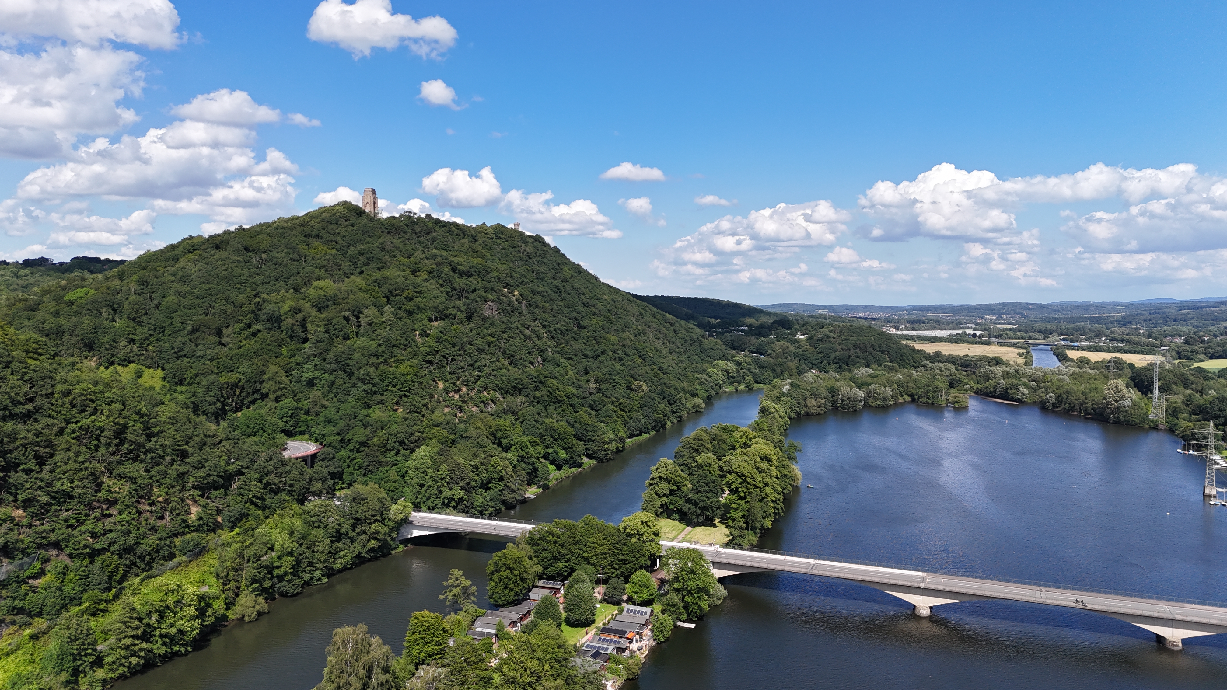 Berg mit Ruhr im Vordergrund und Denkmal auf dem Gipfel