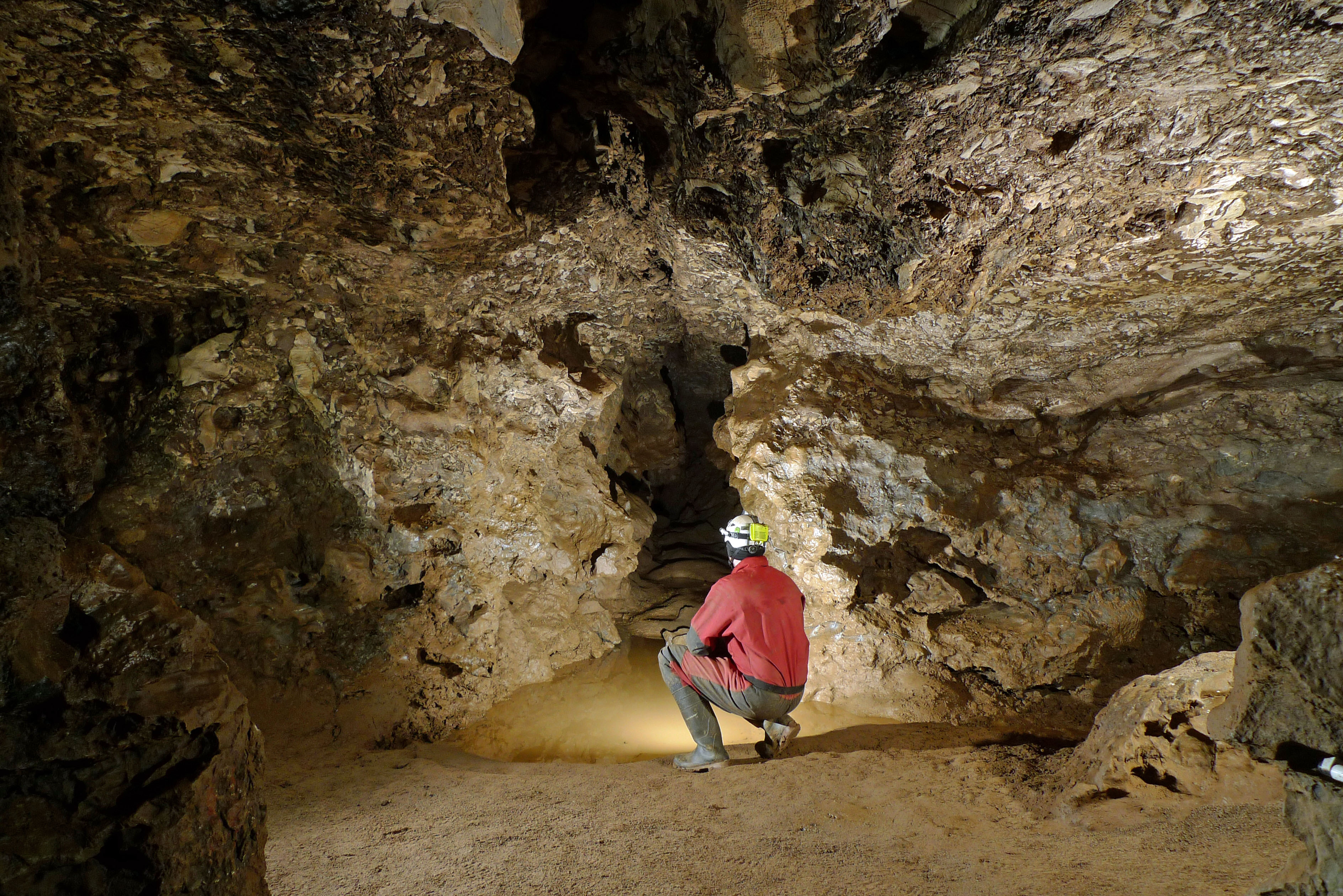 Mann im roten Höhlenanzug in Höhle