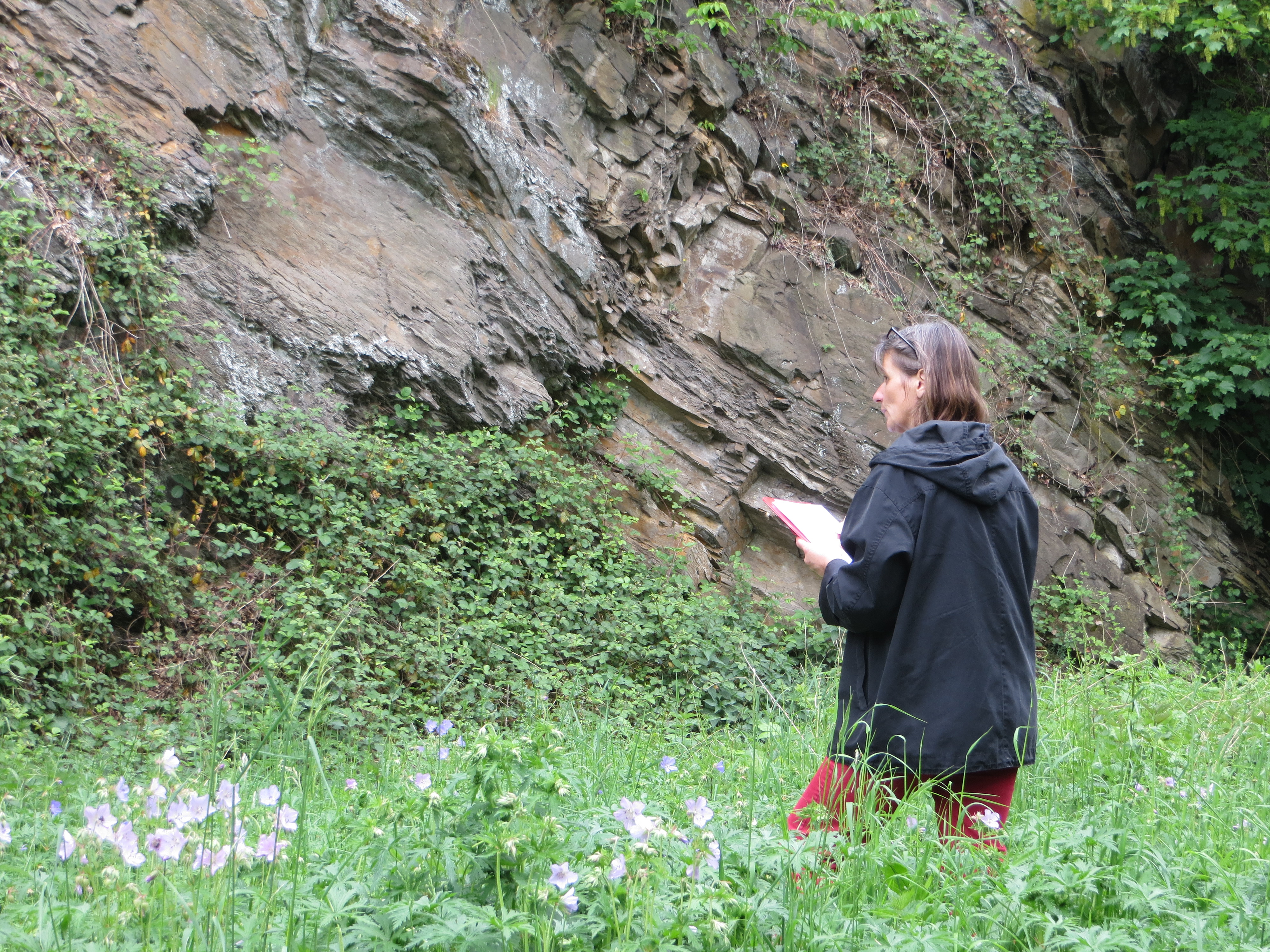 Frau mit Schreibzeug vor Felswand