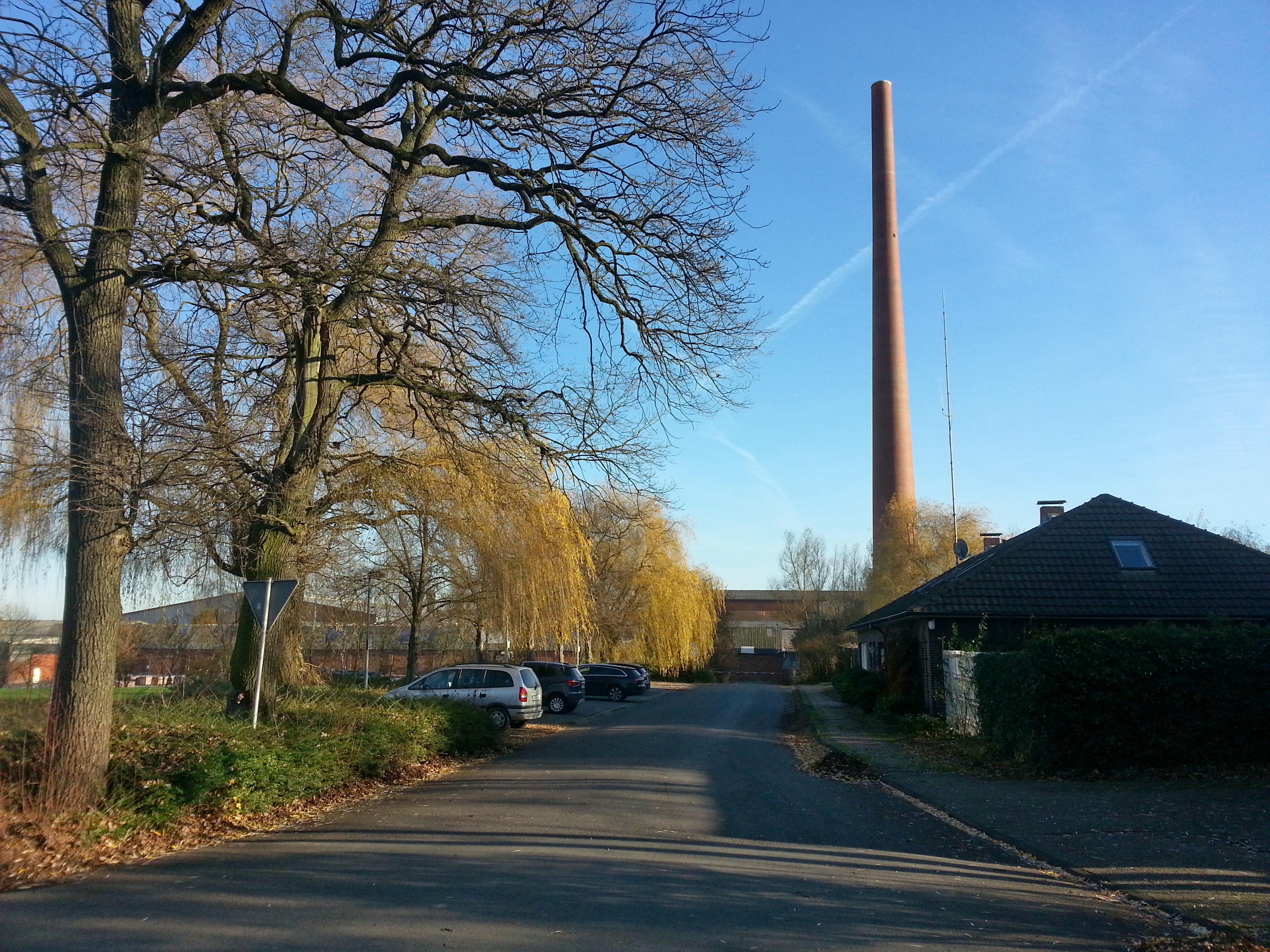 Flache Backsteingebäude und hoher Schornstein