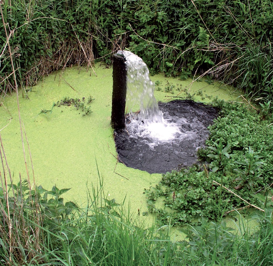Waaserloch mit Rohr, aus dem Wasser sprudelt